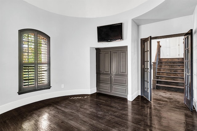 unfurnished bedroom with baseboards and dark wood-type flooring