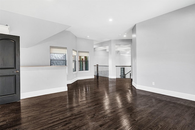 unfurnished living room featuring baseboards, vaulted ceiling, wood finished floors, and recessed lighting