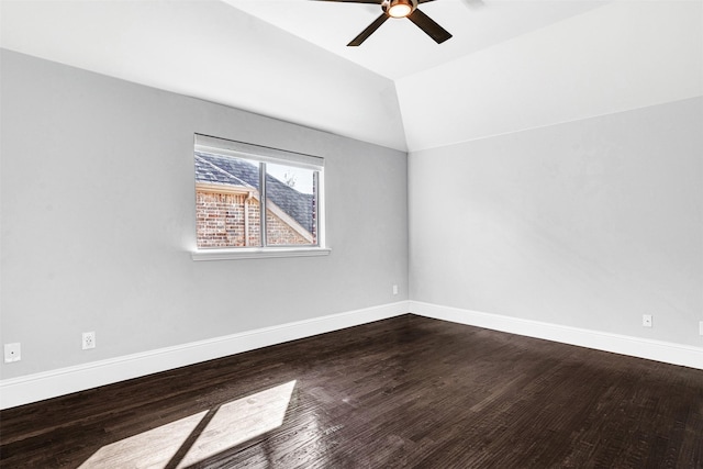 empty room featuring lofted ceiling, ceiling fan, baseboards, and dark wood-type flooring