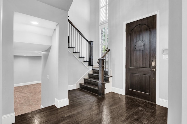 entryway with stairs, wood finished floors, and baseboards