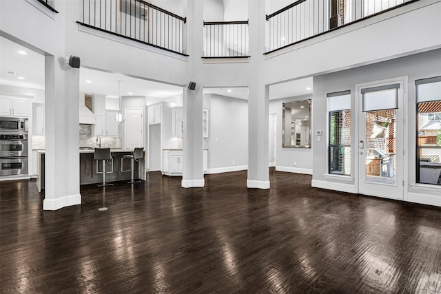 unfurnished living room with recessed lighting, dark wood-style flooring, and baseboards