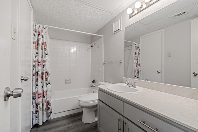 full bathroom with visible vents, toilet, vanity, a textured ceiling, and wood finished floors