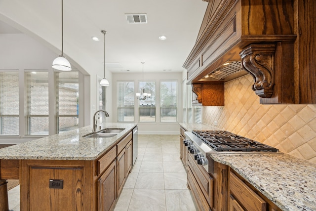 kitchen with a sink, visible vents, appliances with stainless steel finishes, brown cabinets, and decorative backsplash