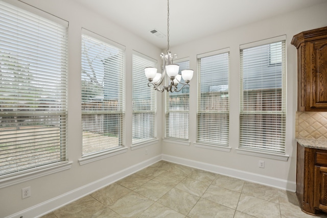 unfurnished dining area with baseboards, visible vents, a notable chandelier, and light tile patterned flooring