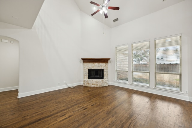 unfurnished living room featuring dark wood-style floors, a fireplace, ceiling fan, high vaulted ceiling, and baseboards