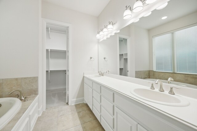 full bath featuring tile patterned flooring, a sink, a spacious closet, and a bath