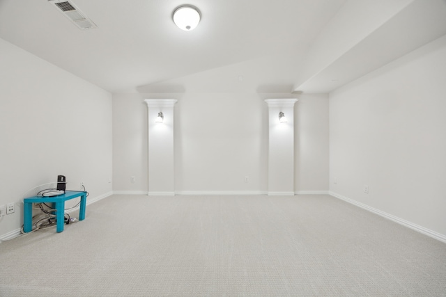 carpeted empty room with lofted ceiling, baseboards, and visible vents