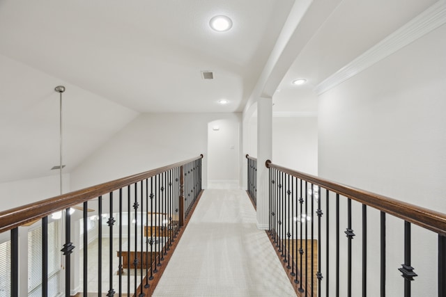 hallway featuring baseboards, visible vents, lofted ceiling, ornamental molding, and recessed lighting