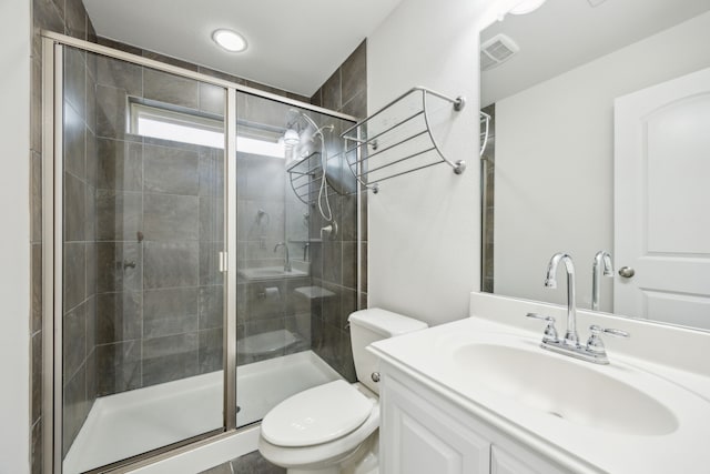 full bathroom featuring a stall shower, visible vents, vanity, and toilet