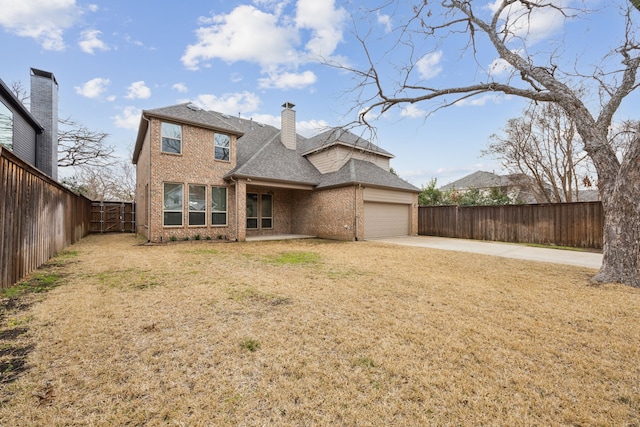 traditional home featuring brick siding, a chimney, a garage, fence private yard, and driveway