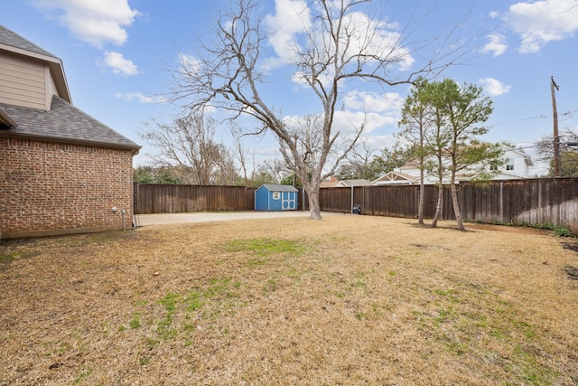 view of yard with an outbuilding, a fenced backyard, and a storage shed