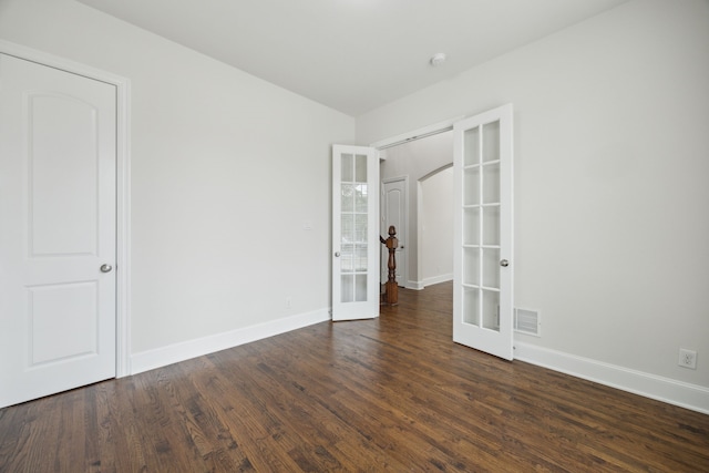 spare room featuring dark wood-type flooring, french doors, visible vents, and baseboards