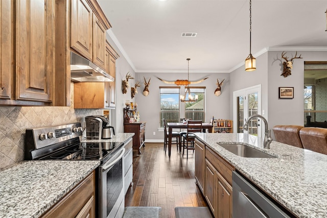 kitchen with under cabinet range hood, stainless steel appliances, dark wood-type flooring, a sink, and backsplash