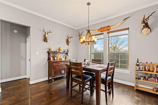 dining space featuring dark wood-type flooring, a notable chandelier, baseboards, and ornamental molding