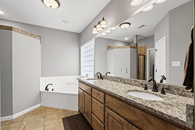 bathroom featuring visible vents, a sink, a garden tub, and tile patterned floors