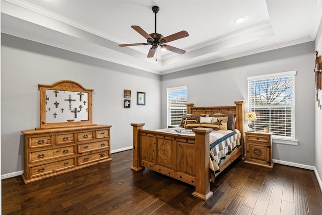 bedroom featuring ornamental molding, baseboards, ceiling fan, dark wood-type flooring, and a raised ceiling