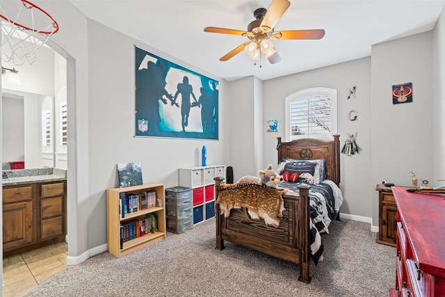 bedroom with a ceiling fan, arched walkways, connected bathroom, and light colored carpet