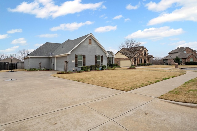 french country home with brick siding, concrete driveway, fence, a garage, and a front lawn