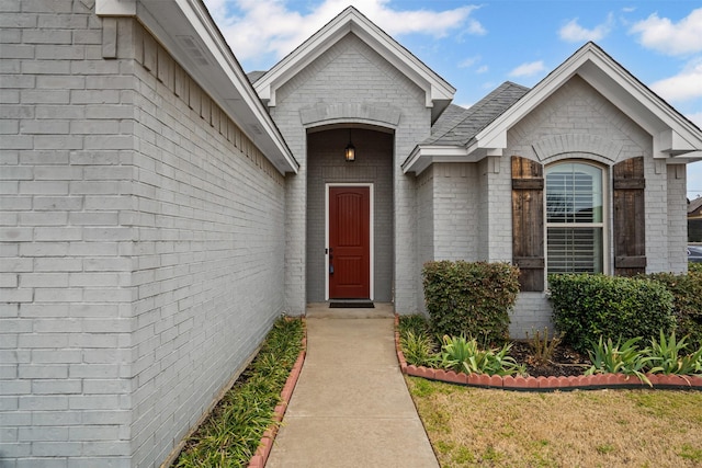 view of exterior entry featuring brick siding