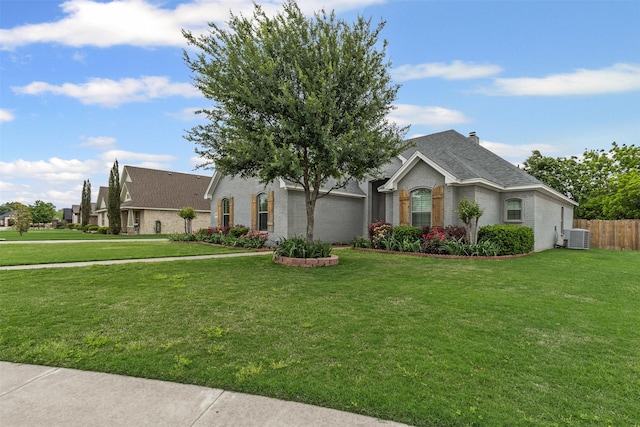 single story home featuring a front yard, central AC unit, brick siding, an attached garage, and a shingled roof