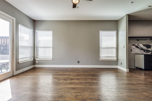 interior space featuring ceiling fan, baseboards, and wood finished floors