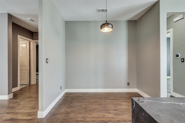 unfurnished dining area with visible vents, baseboards, and wood finished floors