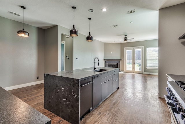 kitchen featuring visible vents, range, wood finished floors, french doors, and a sink