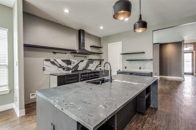 kitchen featuring open shelves, a sink, decorative backsplash, dark wood-style floors, and wall chimney exhaust hood