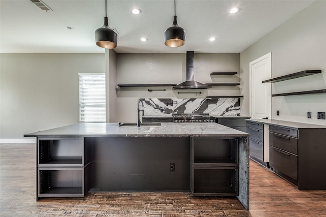 kitchen with open shelves, visible vents, dark wood-type flooring, a sink, and wall chimney exhaust hood