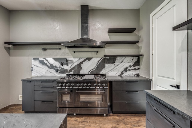 kitchen with wall chimney exhaust hood, double oven range, dark wood-style floors, and gray cabinets