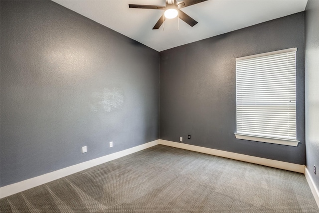 carpeted empty room with baseboards, a ceiling fan, and a textured wall