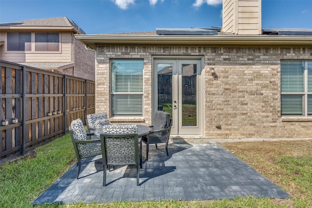 view of patio with a fenced backyard, outdoor dining area, and french doors