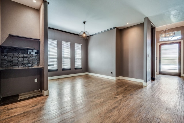 living area with a notable chandelier, baseboards, and wood finished floors