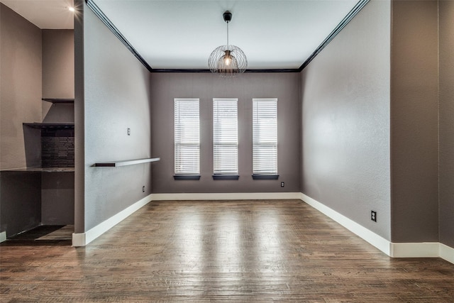 unfurnished dining area with ornamental molding, wood finished floors, and baseboards