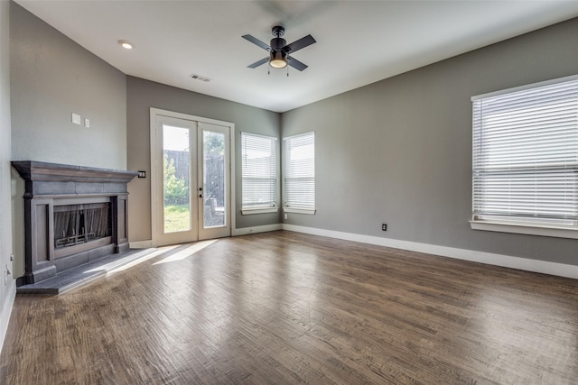 unfurnished living room featuring wood finished floors, a ceiling fan, visible vents, baseboards, and french doors