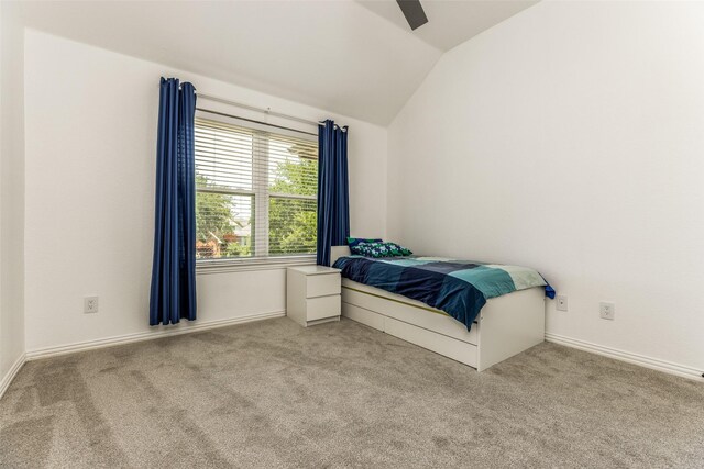 carpeted bedroom with vaulted ceiling, ceiling fan, and baseboards