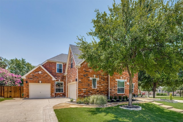 view of front of home with brick siding, a shingled roof, fence, concrete driveway, and a front yard