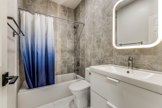 full bathroom featuring marble finish floor, tile walls, toilet, shower / tub combo, and vanity