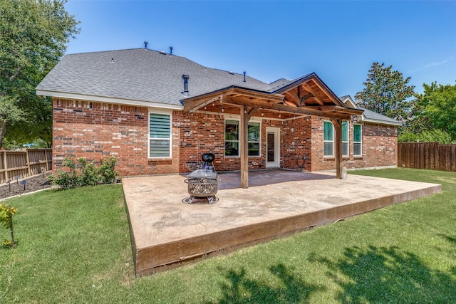 back of property featuring brick siding, a yard, a patio, an outdoor fire pit, and fence private yard