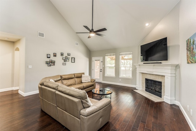 living area featuring ceiling fan, high vaulted ceiling, wood finished floors, baseboards, and a tiled fireplace