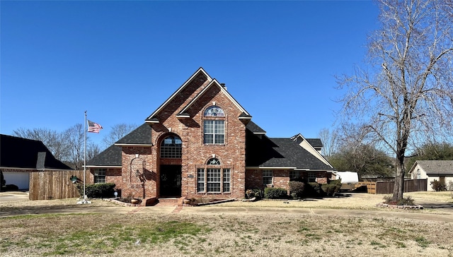 view of front of home featuring fence and brick siding