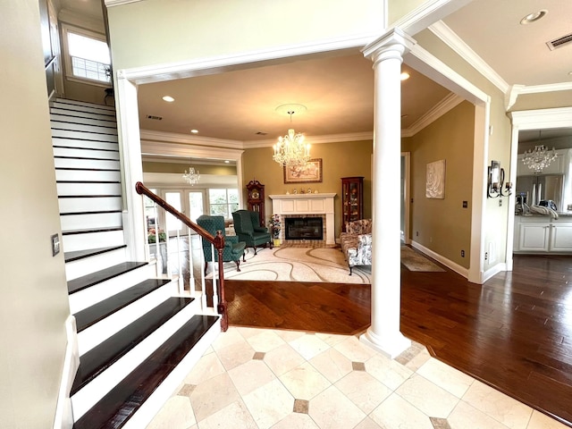 entrance foyer with a healthy amount of sunlight, decorative columns, stairs, and a chandelier