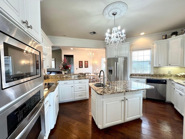 kitchen with stainless steel appliances, an inviting chandelier, dark wood-type flooring, a sink, and a peninsula