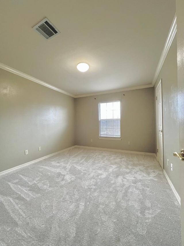 spare room featuring ornamental molding, light colored carpet, visible vents, and baseboards