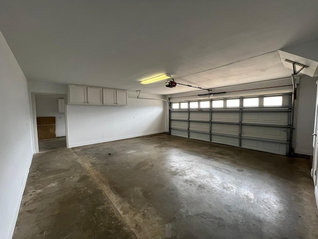 garage with a garage door opener and baseboards