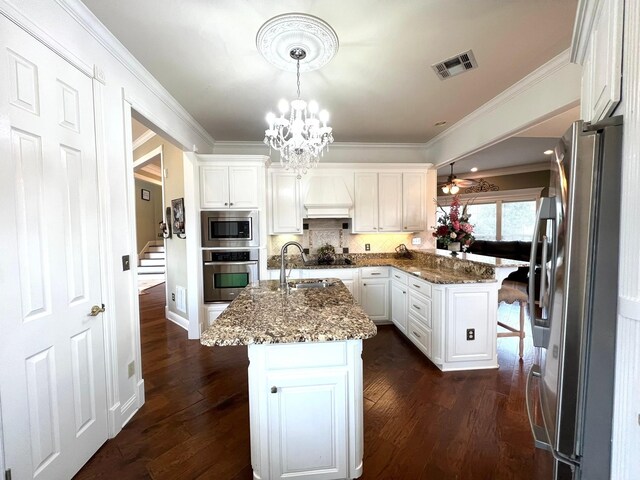 kitchen featuring stainless steel appliances, white cabinetry, a breakfast bar area, and dark wood-style floors