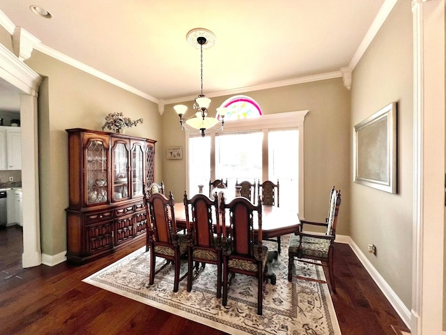 dining space featuring crown molding, dark wood-style flooring, and a notable chandelier