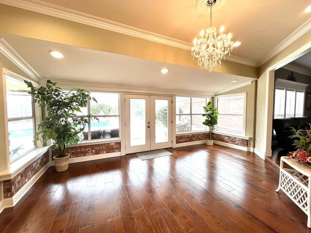 interior space with ornamental molding, french doors, a chandelier, and dark wood-style flooring