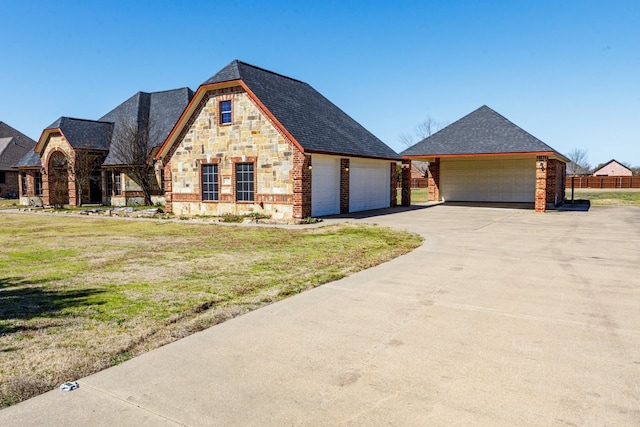 view of front of home with stone siding, a shingled roof, fence, and a front yard