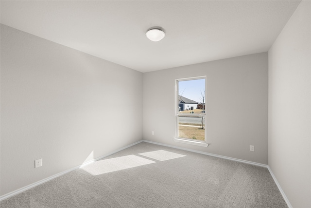 carpeted spare room featuring baseboards